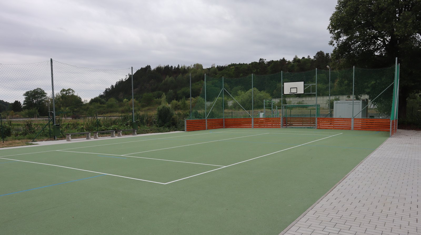 Surová fotka: prázdné sportovní hřiště pod zataženou oblohou