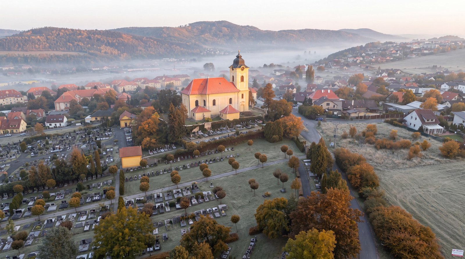 Hotový záběr: kostel a město v mlhavém podzimním ránu