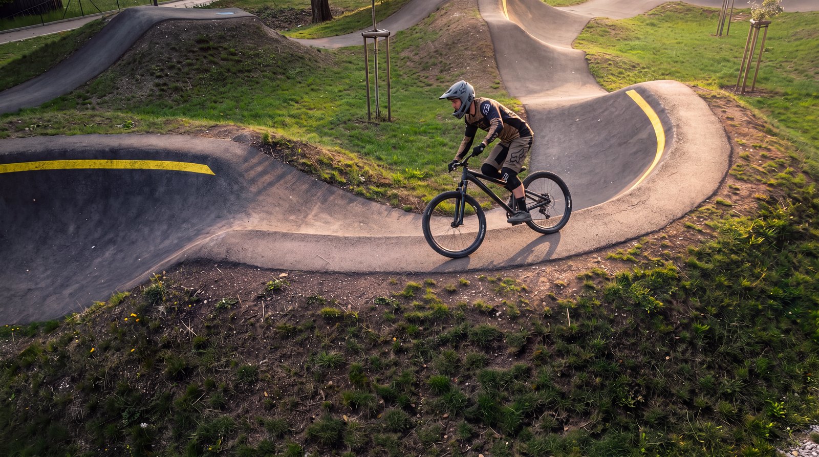 Hotový záběr: jezdec na kole na pumptracku v podvečerním světle